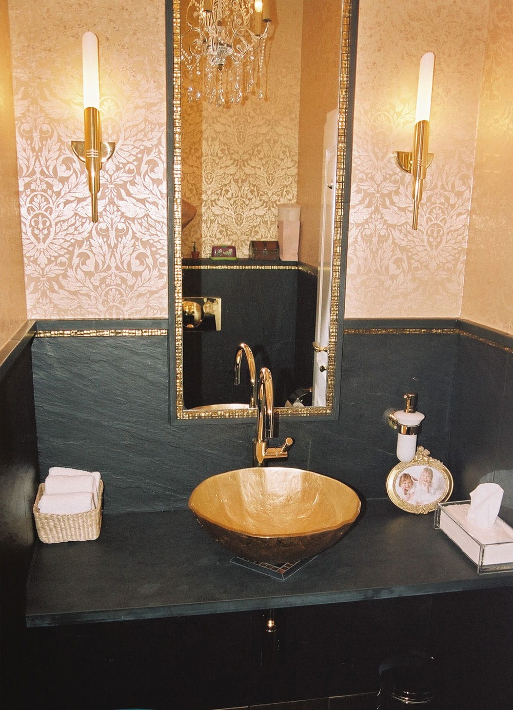 Elegantes Gäste-WC mit goldener Aufsatzschale, schwarzem Schiefer an Wand und Konsole, goldene Damast-Tapete