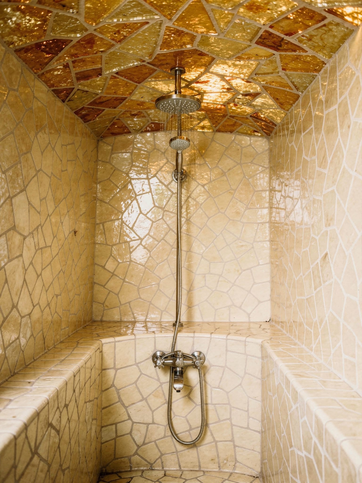 Dampfbadnische komplett mit goldbeigem Bruchmosaik verkleidet, Regenbrause mittig in der gewoelbten Decke